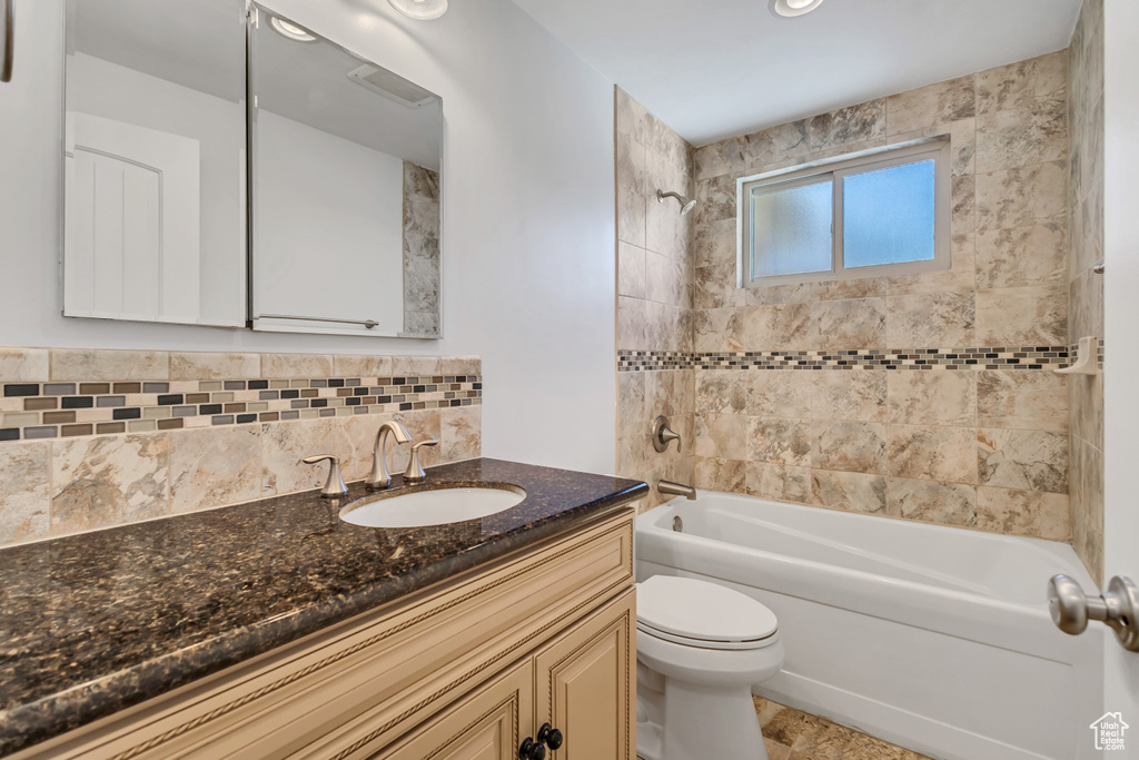 Full bathroom featuring toilet, tasteful backsplash, shower / bathing tub combination, and vanity