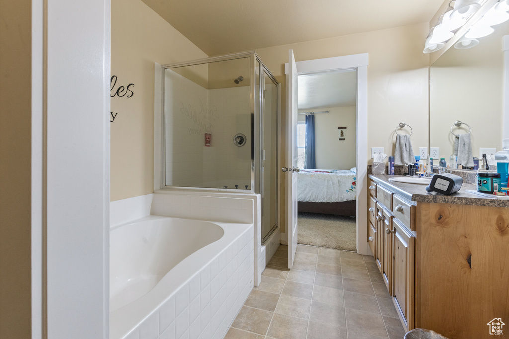 Full bath featuring connected bathroom, tile patterned floors, a bath, a shower stall, and vanity