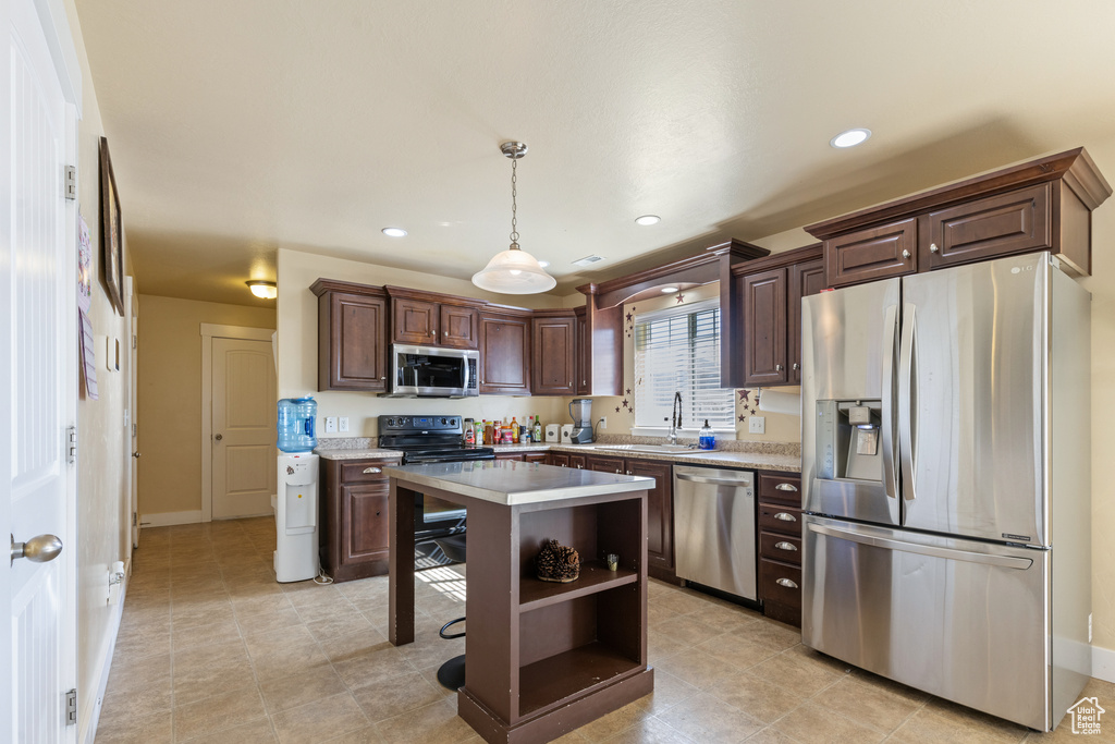 Kitchen featuring a sink, open shelves, dark brown cabinetry, light countertops, and appliances with stainless steel finishes