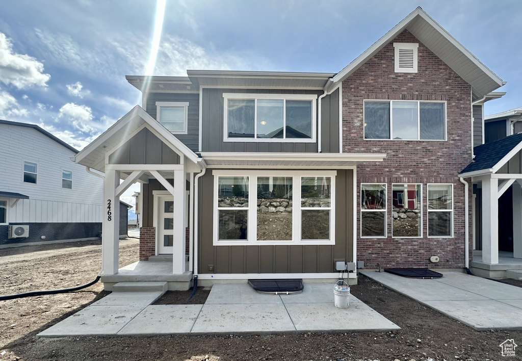 View of front facade featuring board and batten siding and brick siding