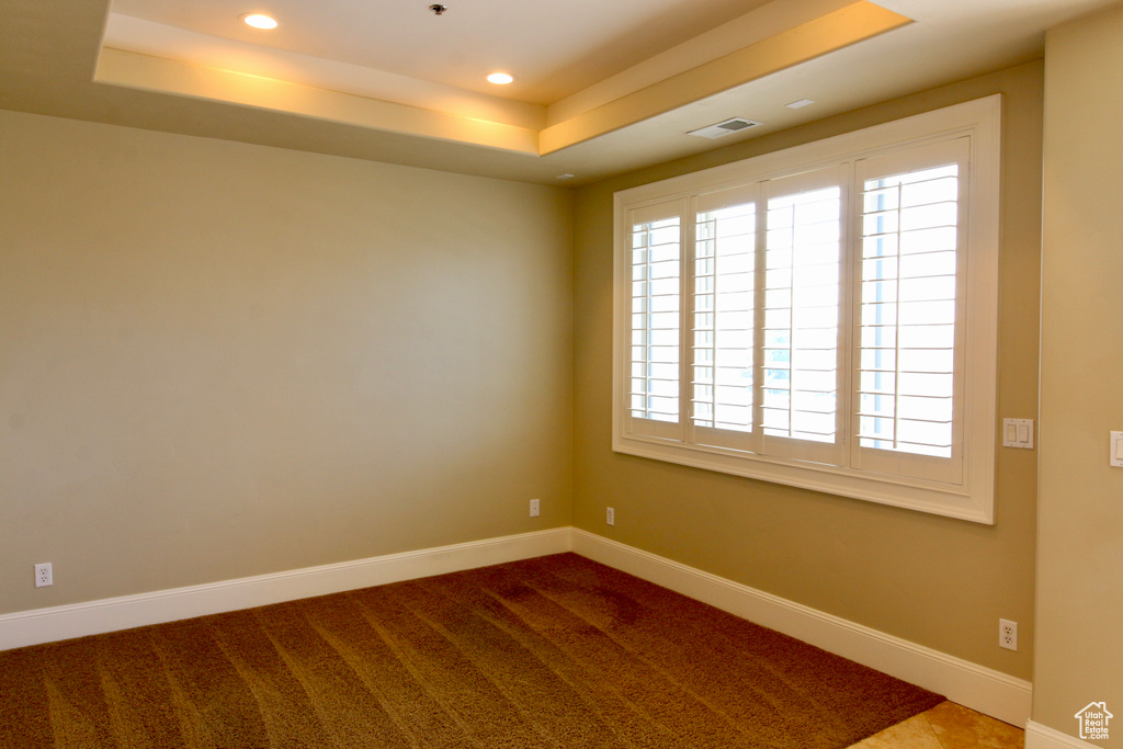 Carpeted empty room with recessed lighting, a healthy amount of sunlight, a tray ceiling, and visible vents