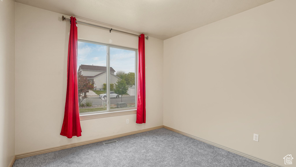 Spare room featuring baseboards, visible vents, and carpet