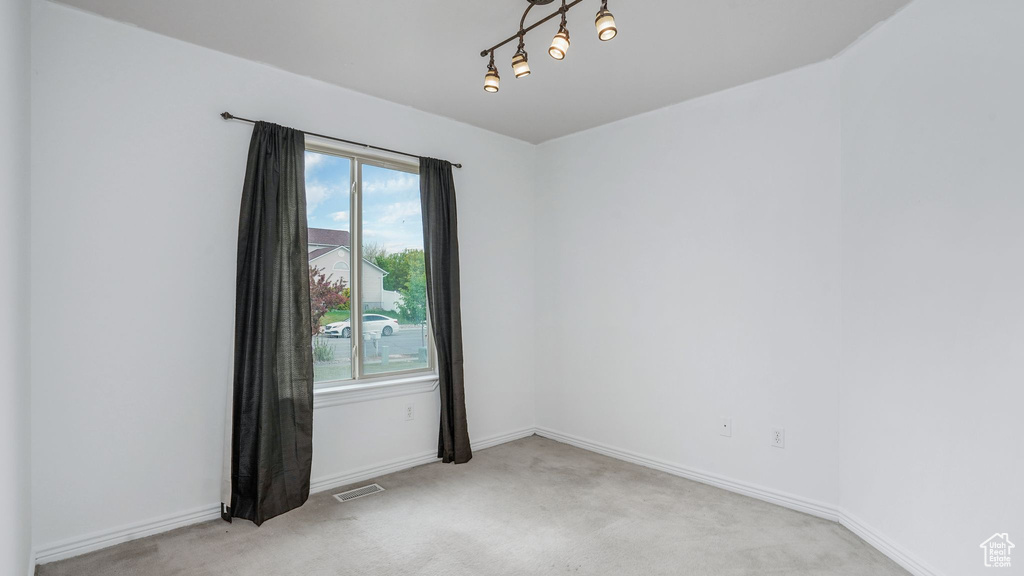 Unfurnished room with visible vents, baseboards, and light carpet