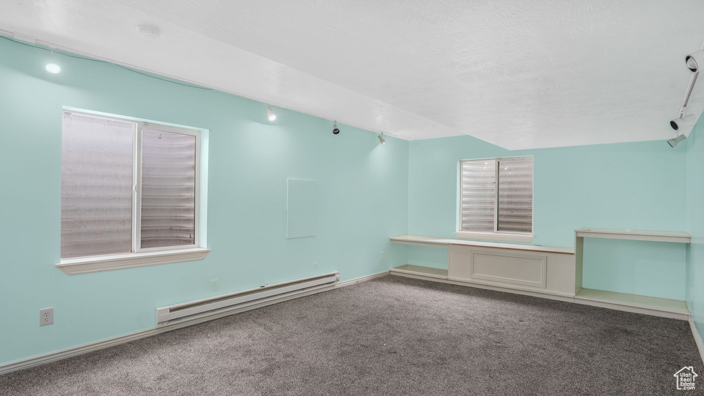 Empty room featuring carpet flooring and a baseboard heating unit
