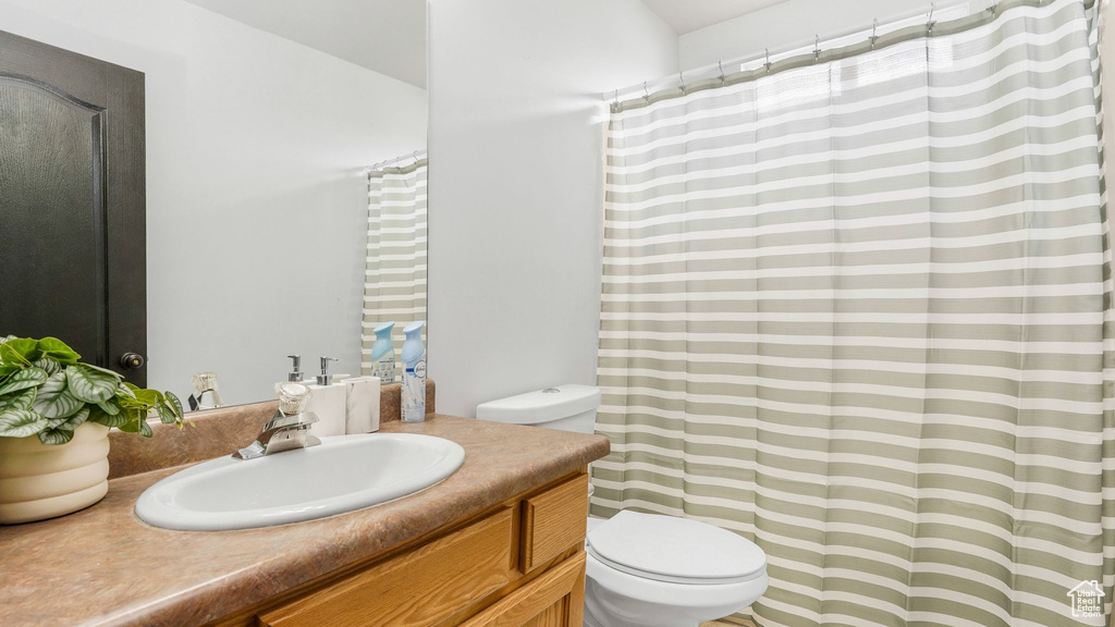 Full bathroom with vanity, toilet, and a shower with shower curtain