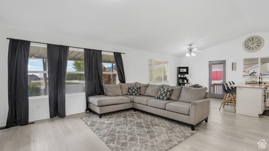 Living area with light wood finished floors, vaulted ceiling, and ceiling fan