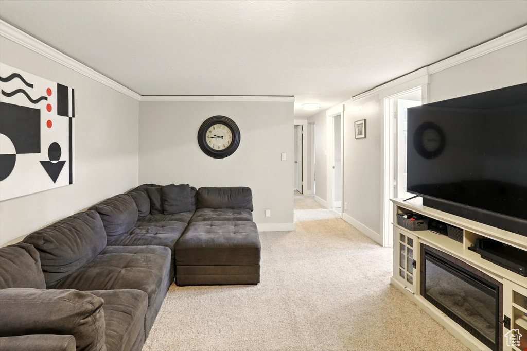 Living room with light colored carpet, ornamental molding, and baseboards