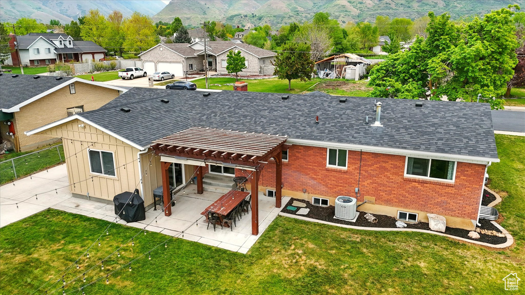 Rear view of property with a residential view, cooling unit, a pergola, board and batten siding, and brick siding