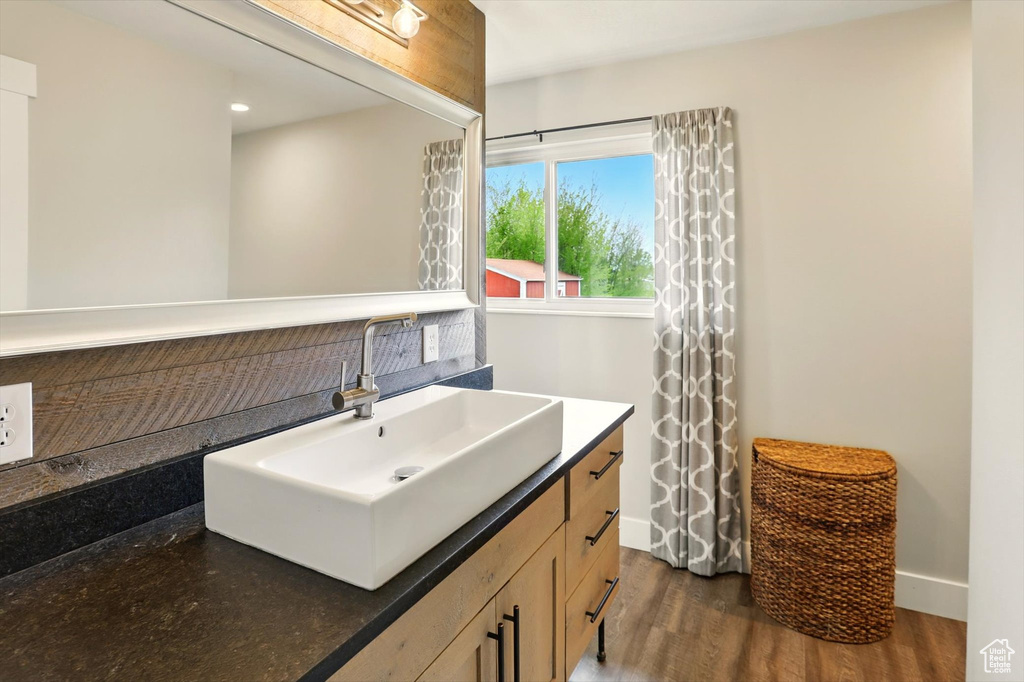 Bathroom with baseboards, vanity, and wood finished floors