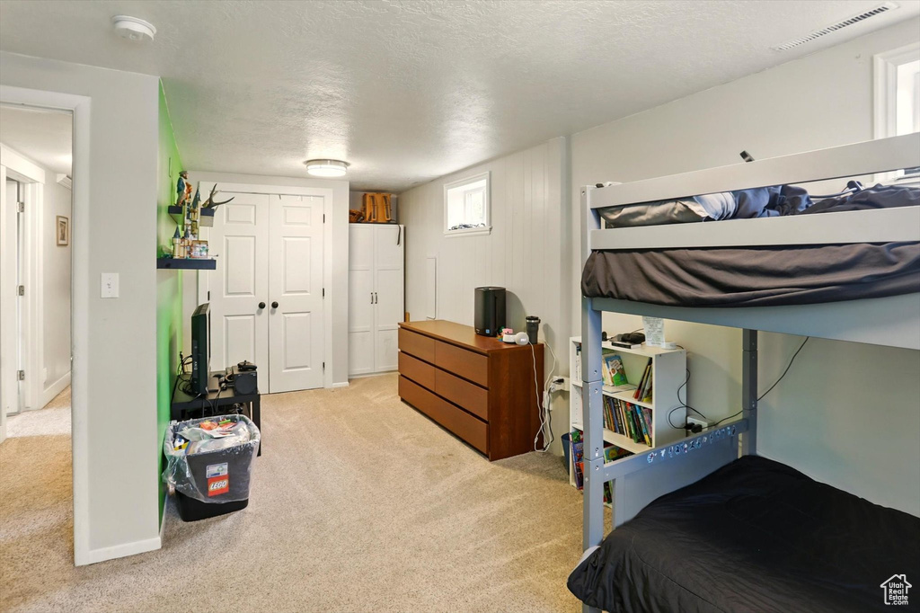 Bedroom featuring light carpet, a closet, and visible vents