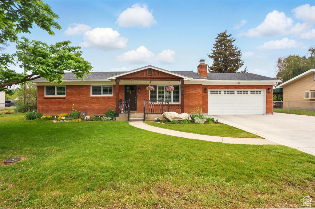 Ranch-style house featuring concrete driveway, a garage, a chimney, and brick siding