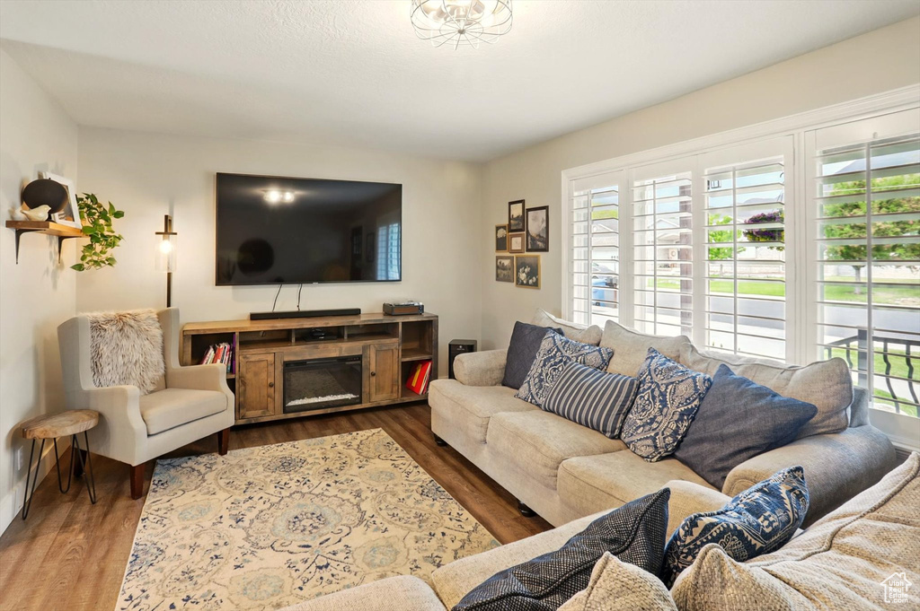 Living room featuring a glass covered fireplace and wood finished floors