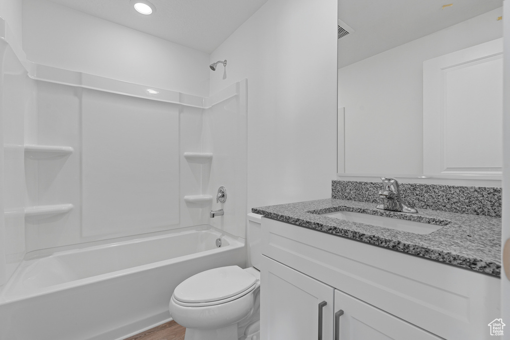 Full bathroom featuring toilet, wood finished floors, vanity, recessed lighting, and bathtub / shower combination