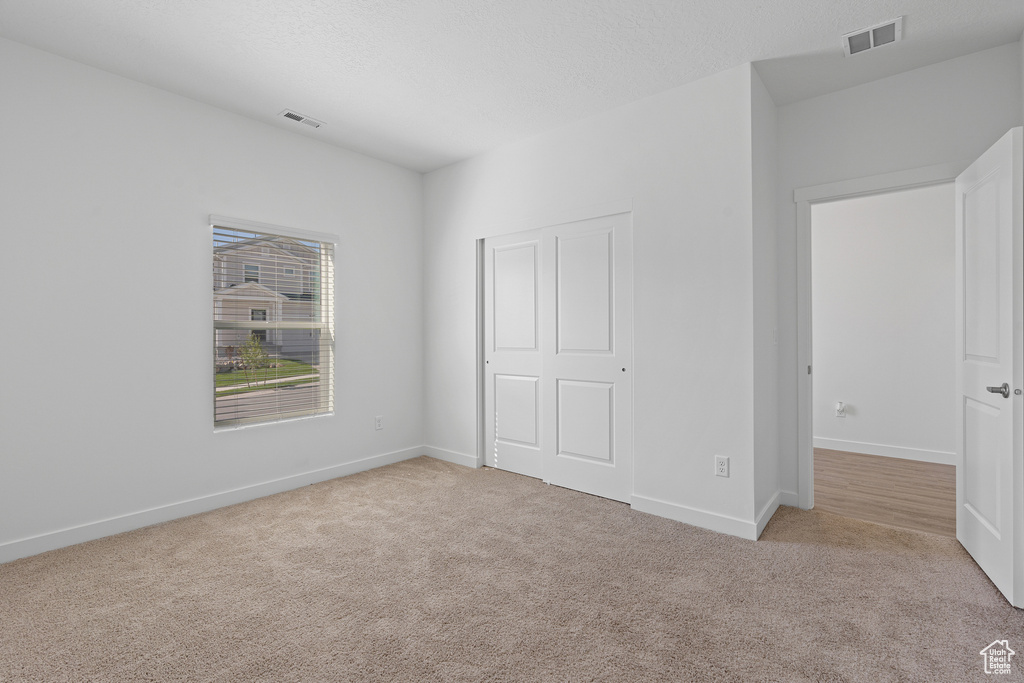 Unfurnished bedroom featuring carpet floors, baseboards, and visible vents