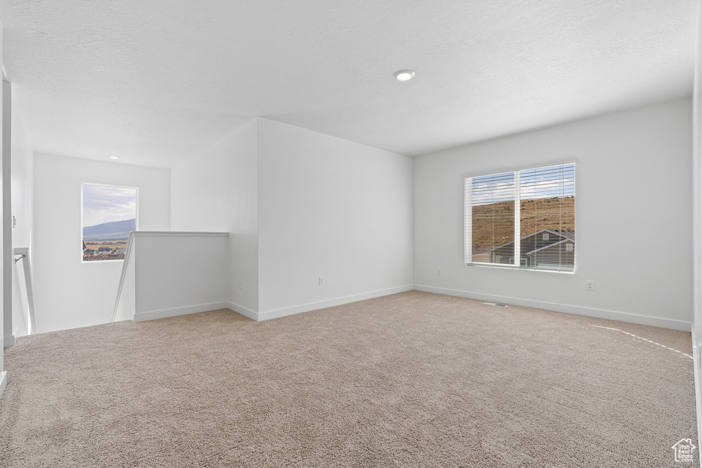 Unfurnished room featuring baseboards, light carpet, and recessed lighting