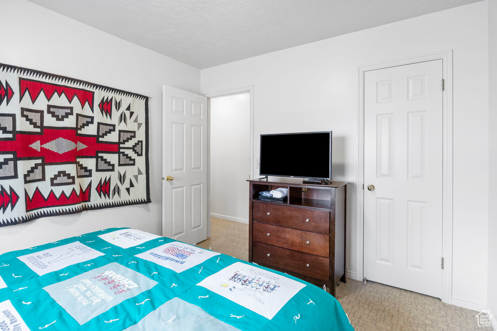 Bedroom featuring a textured ceiling, baseboards, and carpet floors