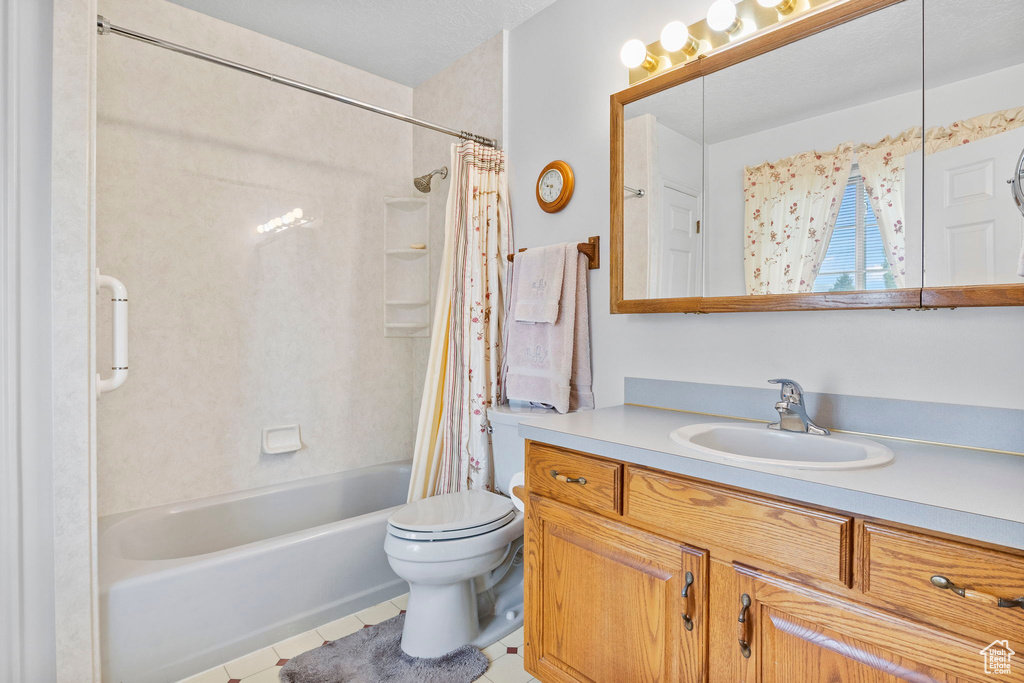 Full bath featuring tile patterned floors, toilet, shower / tub combo, and vanity