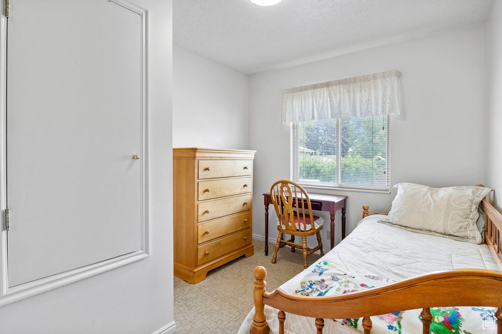 Bedroom with light carpet and baseboards