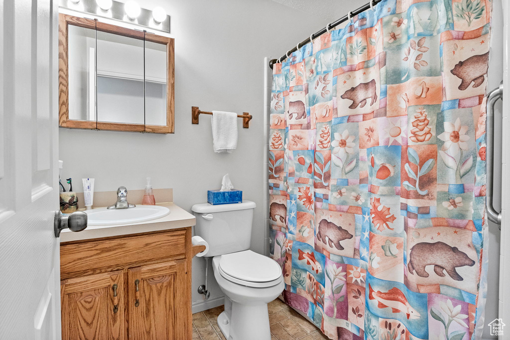 Bathroom featuring vanity, toilet, and a shower with curtain