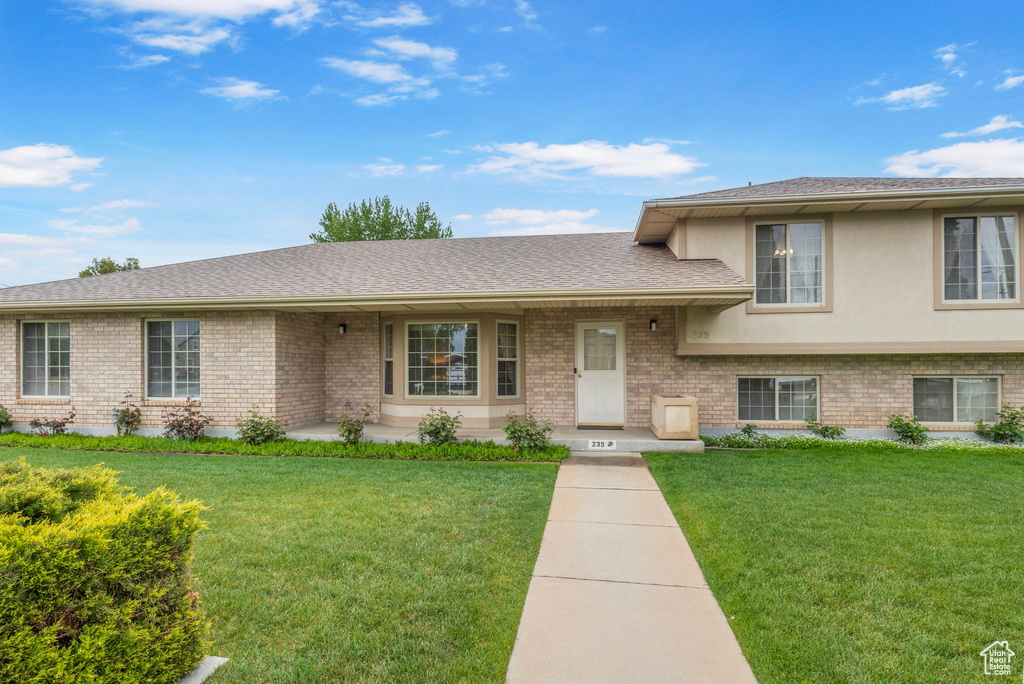 Tri-level home featuring brick siding and a front lawn
