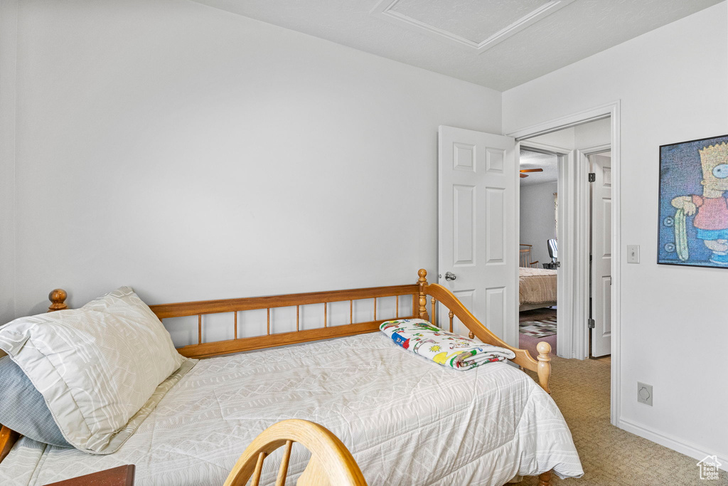 Bedroom with carpet, attic access, and baseboards