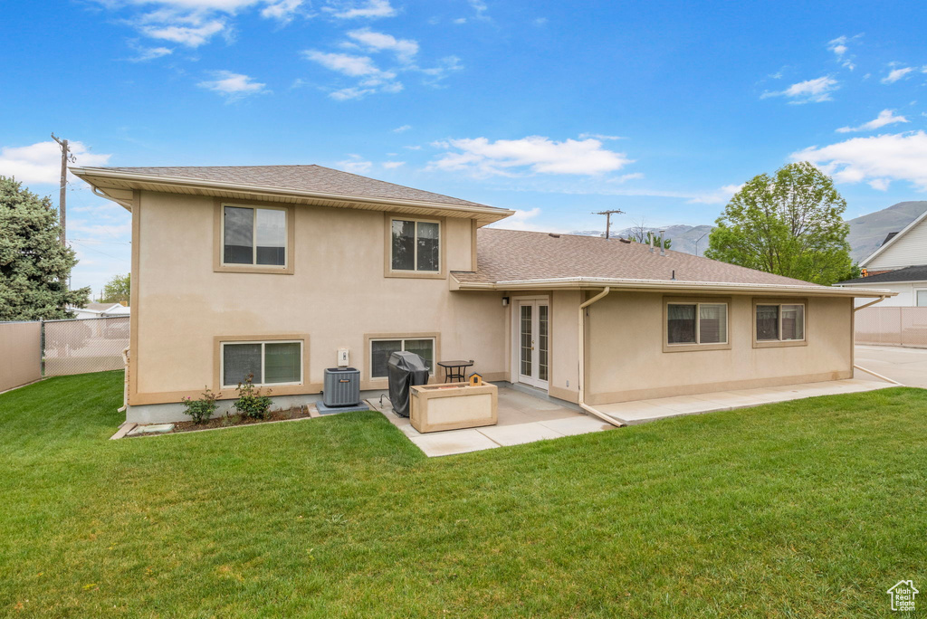 Back of house with a lawn, stucco siding, fence, and a patio