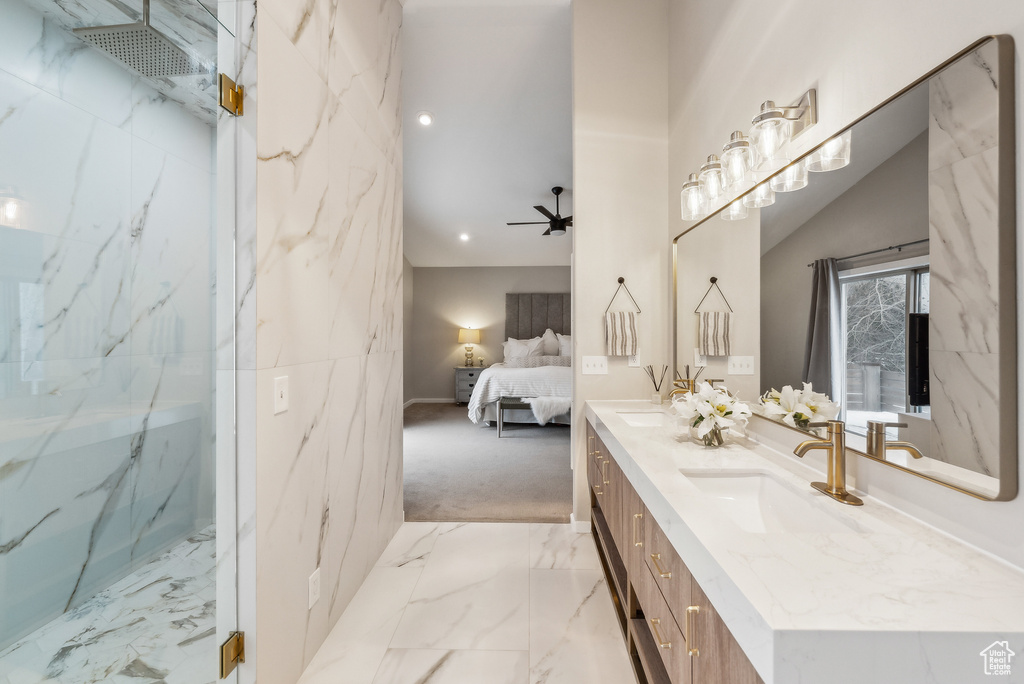 Ensuite bathroom featuring a ceiling fan, marble finish floor, ensuite bath, a sink, and double vanity