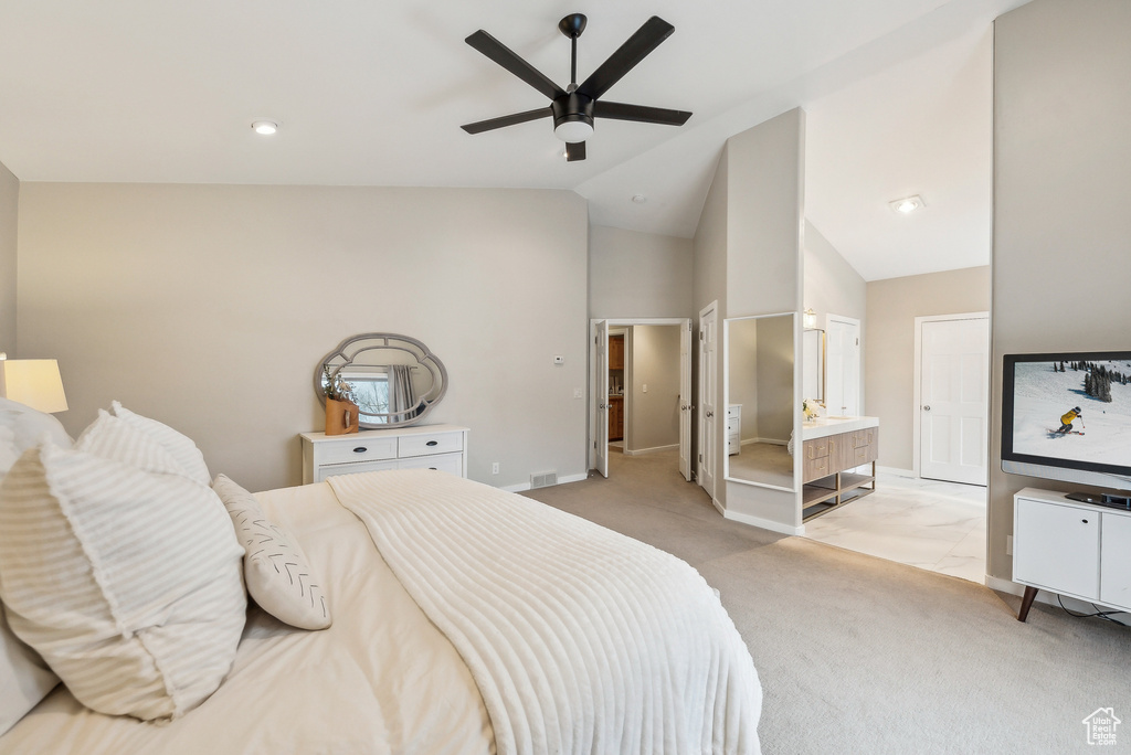 Bedroom featuring lofted ceiling, a ceiling fan, baseboards, connected bathroom, and light colored carpet