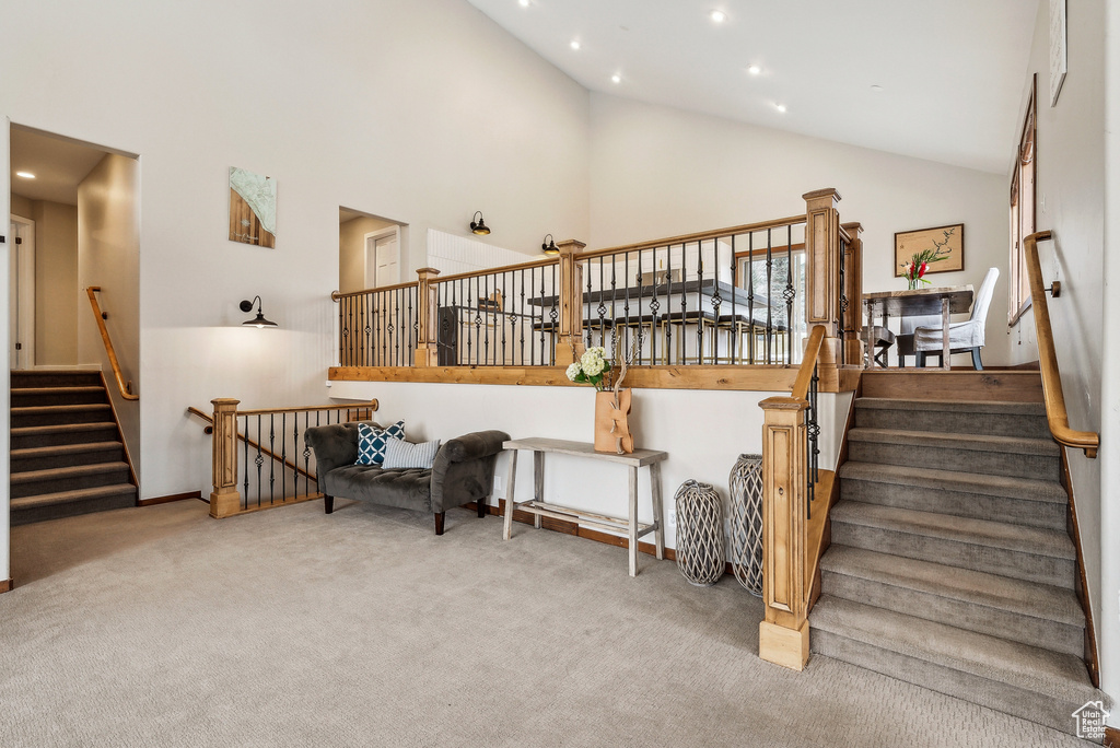 Stairway with baseboards, recessed lighting, carpet flooring, and high vaulted ceiling