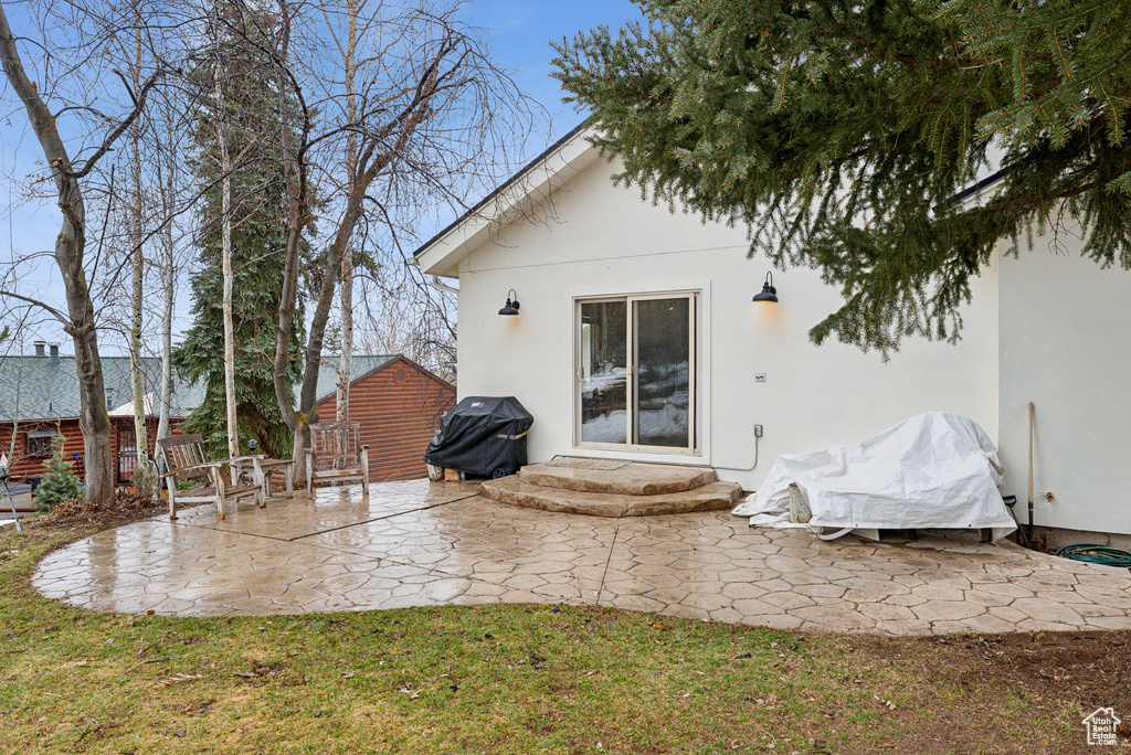 Back of house with a patio, stucco siding, and a lawn