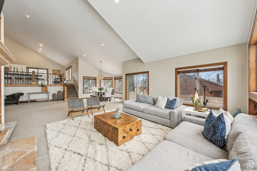 Carpeted living area with stairway, high vaulted ceiling, and recessed lighting