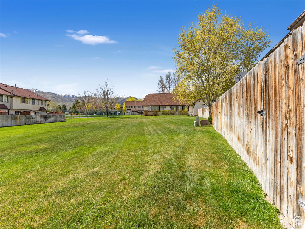 View of yard with a mountain view and fence