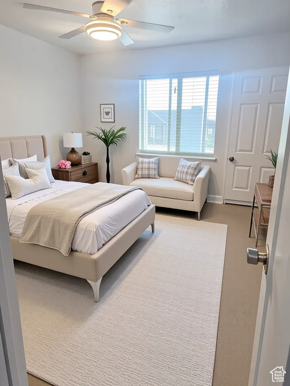 Bedroom featuring a ceiling fan and carpet