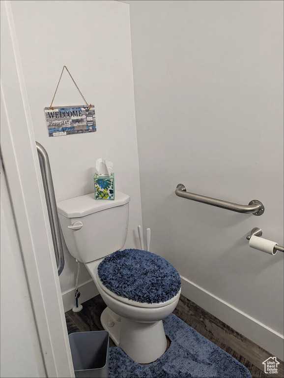 Bathroom with baseboards, toilet, and wood finished floors