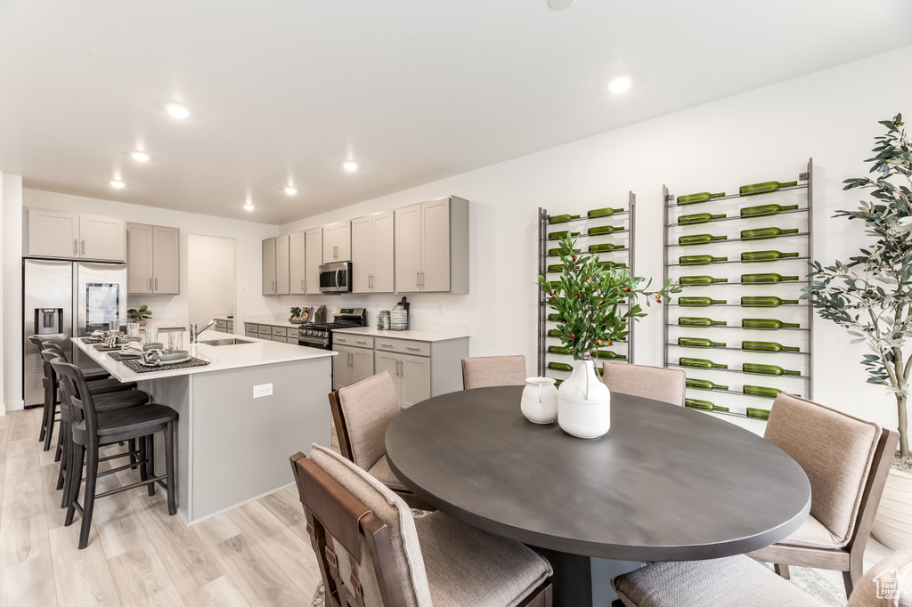 Kitchen with gray cabinets, stainless steel appliances, a kitchen breakfast bar, and a sink