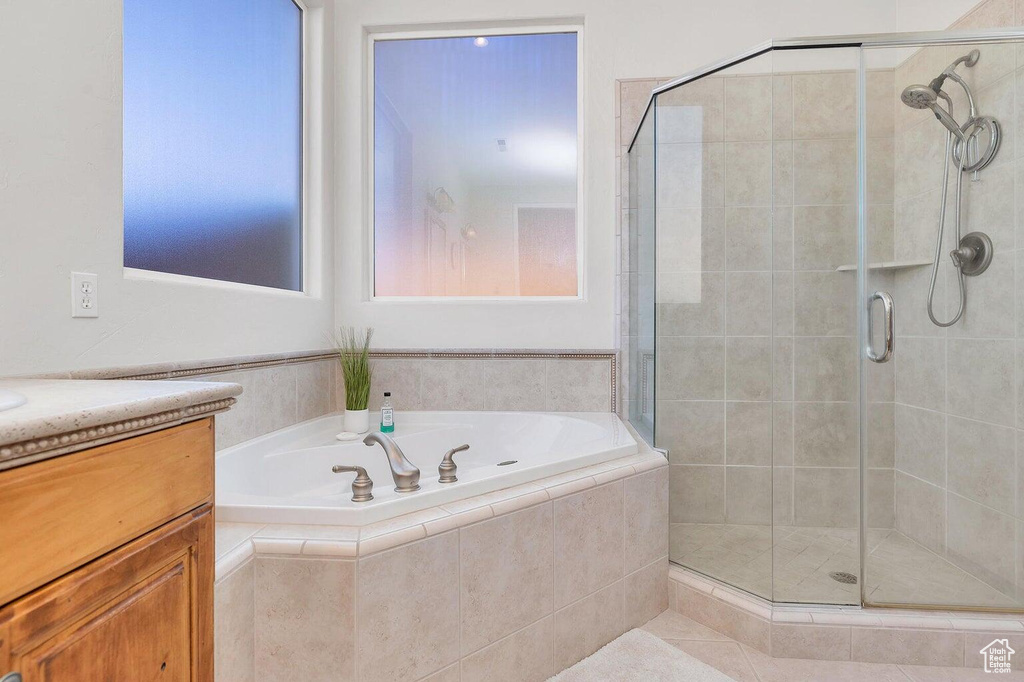 Bathroom with a bath, vanity, and a shower stall