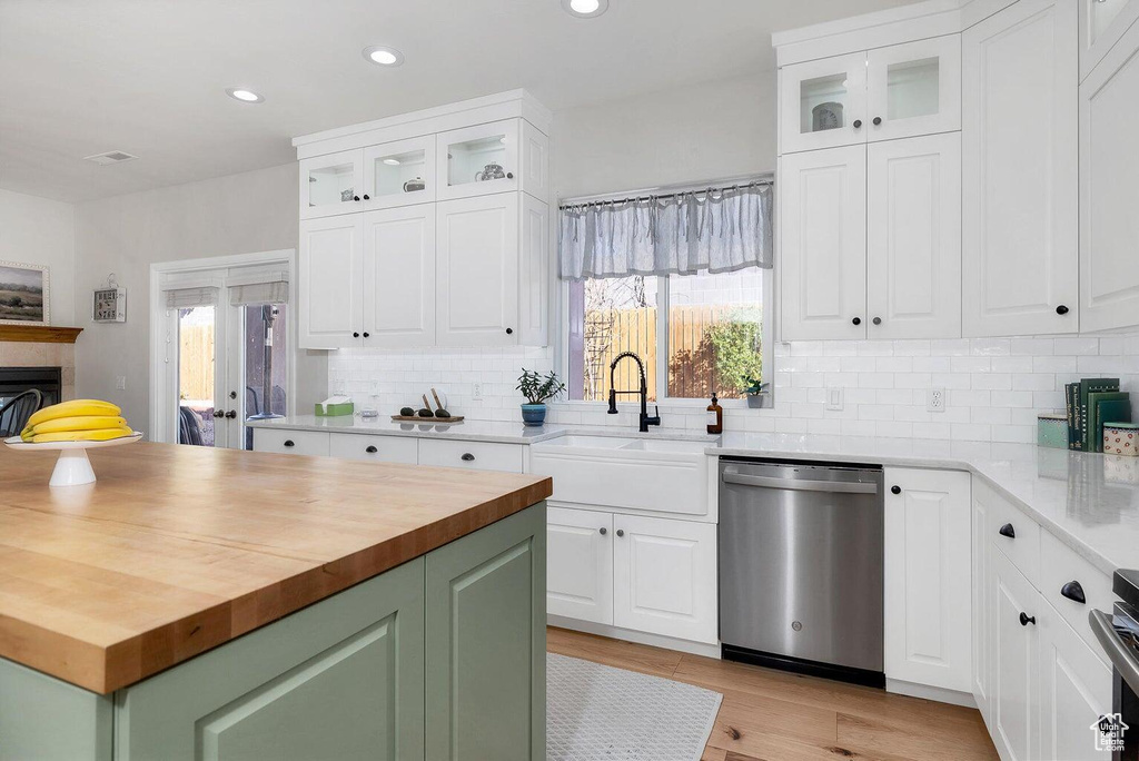 Kitchen with recessed lighting, dishwasher, wooden counters, and a sink
