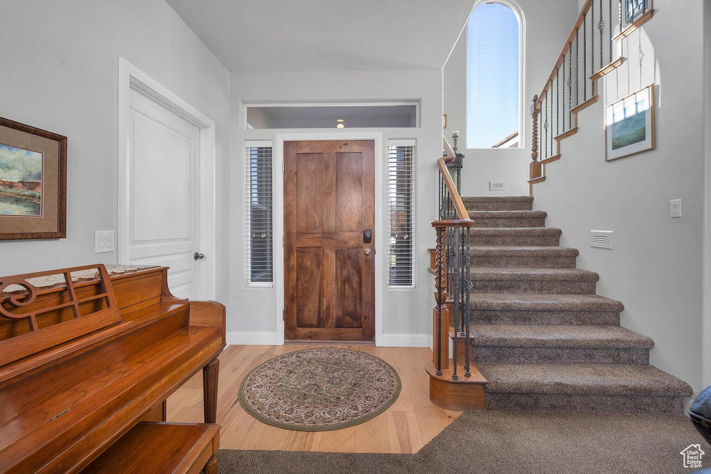 Entryway with stairs, baseboards, and wood finished floors