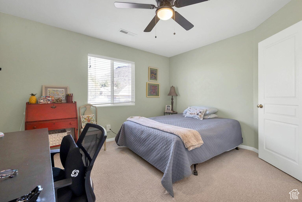 Bedroom featuring light carpet, baseboards, a ceiling fan, and visible vents