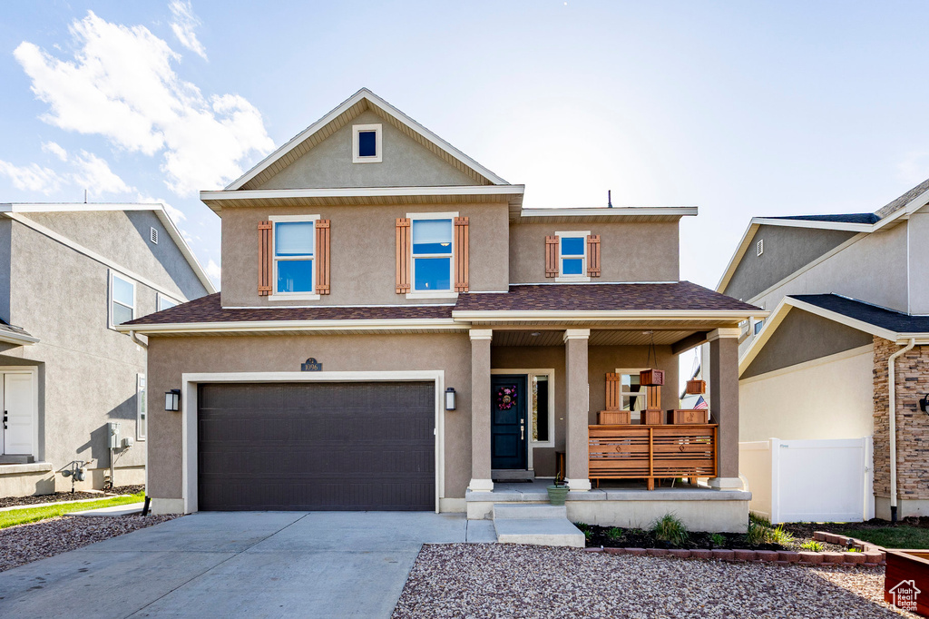 View of front of home with covered porch, stucco siding, a garage, concrete driveway, and a shingled roof