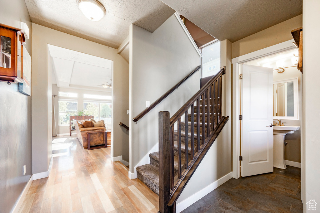 Stairway with a textured ceiling and baseboards