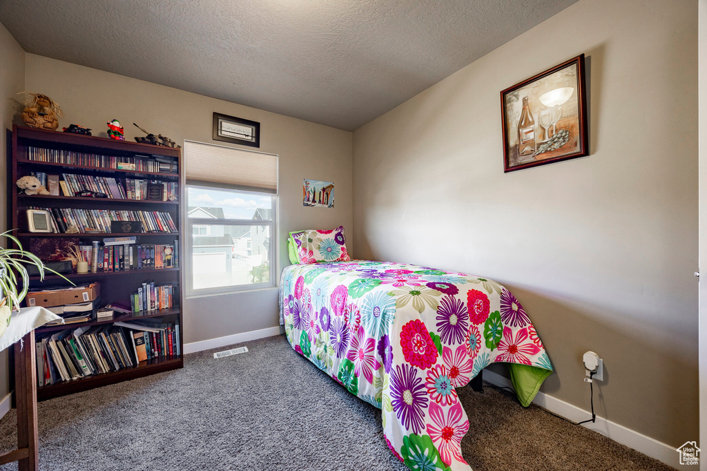 Bedroom featuring a textured ceiling, visible vents, baseboards, and carpet floors