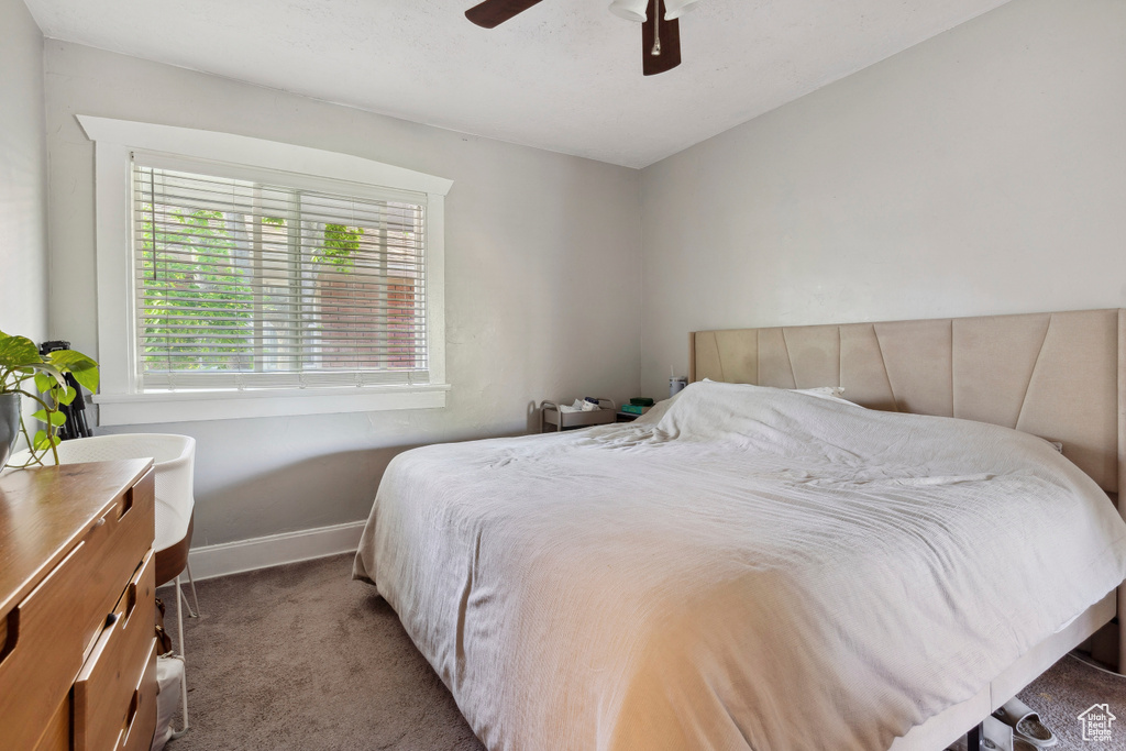 Bedroom featuring baseboards, a ceiling fan, and carpet