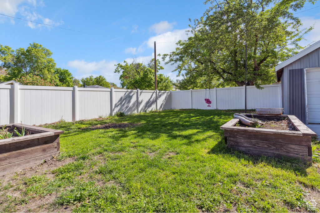 View of yard featuring a garden and a fenced backyard