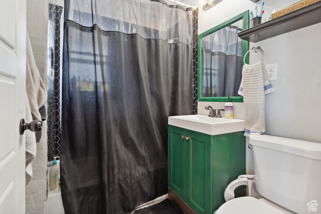 Full bathroom with toilet, shower / tub combo, and vanity