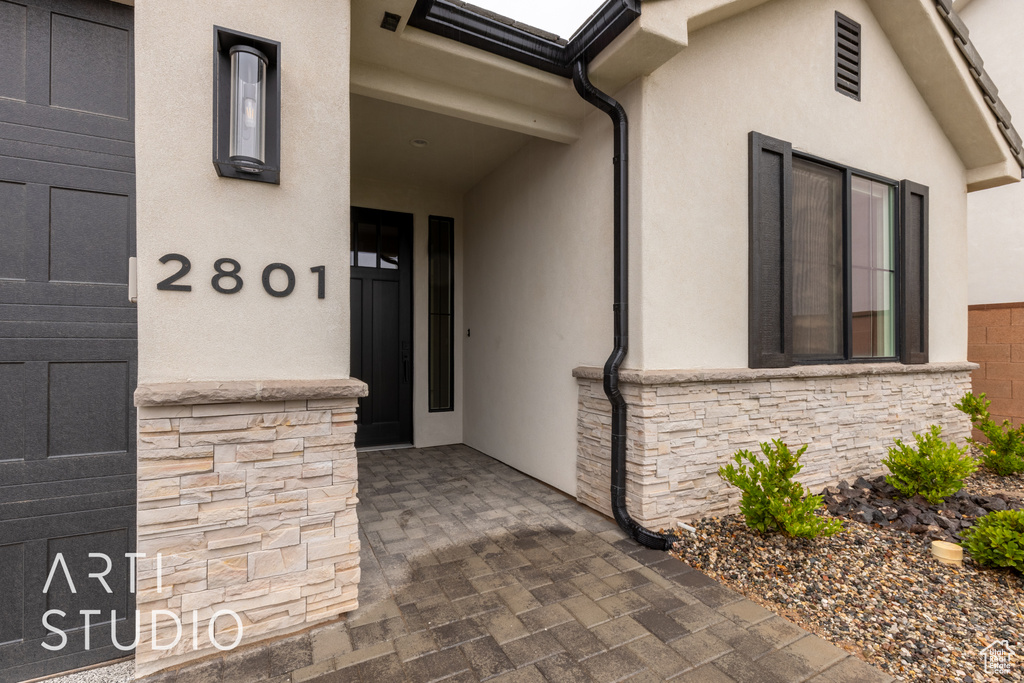 Property entrance featuring stone siding and stucco siding