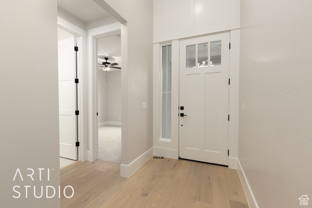 Entrance foyer featuring light wood finished floors, baseboards, and ceiling fan
