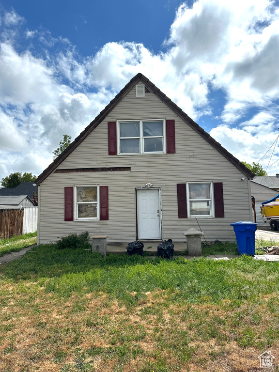 Back of house with a yard and fence