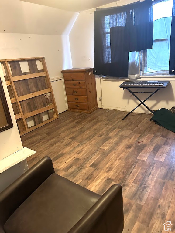 Interior space featuring lofted ceiling and dark wood-style floors
