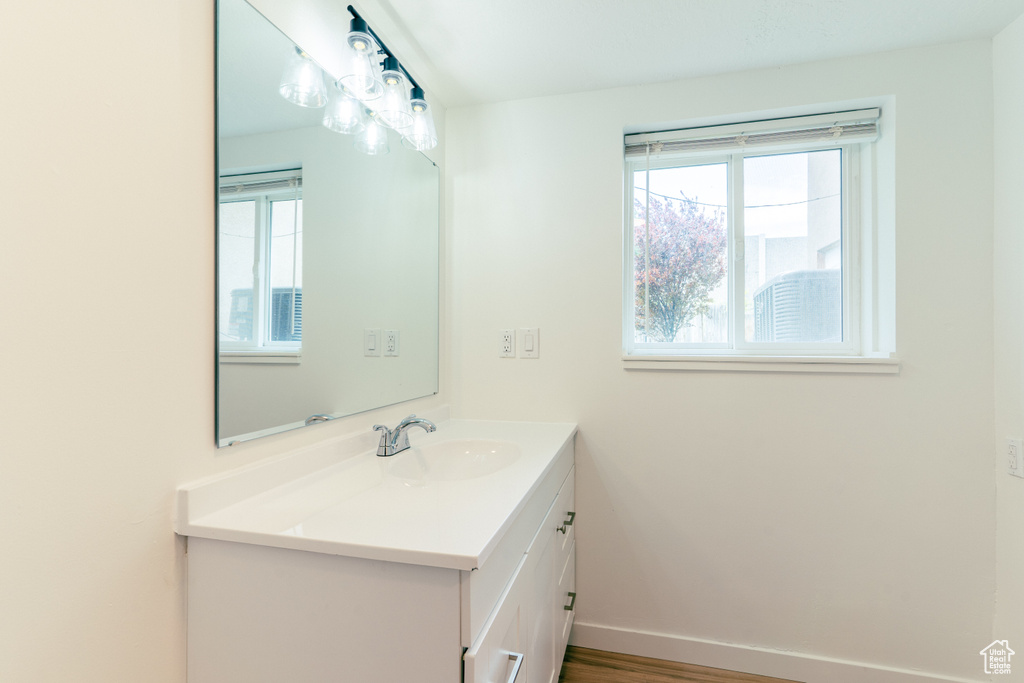 Bathroom featuring baseboards, vanity, and a healthy amount of sunlight